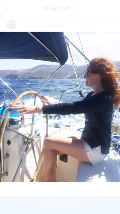 Red-headed-young-woman-steering-yacht-Cyclades-Greece