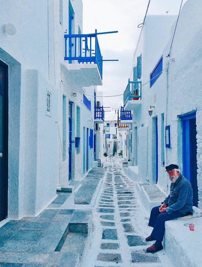 old-man-white-houses-blue-door-Mykonos-Greece